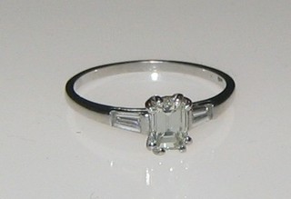 A lady's 18ct white gold dress ring set a rectangular cut diamond and with 2 baguette cut diamonds to the shoulders (approx 0.50/0.18ct)