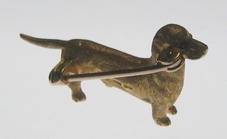 A 9ct gold brooch in the form of a Dachshund with a ruby set eye