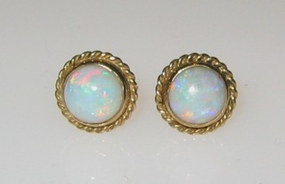 A pair of gold and opal stud earrings