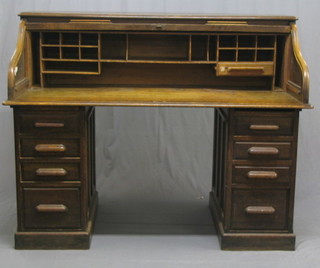 A Victorian oak pedestal roll top desk, the interior fitted pigeon holes, the pedestals fitted 8 long drawers, 60"