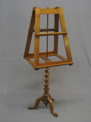 A Victorian walnut duet stand raised on a spiral turned column with tripod base