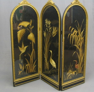 A Victorian arch shaped gilt painted wooden draft screen with wool work panel depicting tropical scenes with animals