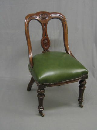 A Victorian mahogany tub back chair with carved pierced splat back, the seat upholstered in green hide and raised on turned and fluted supports