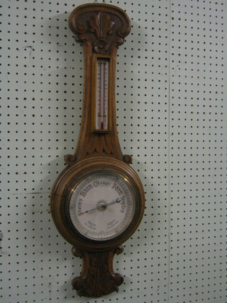 A 19th/20th Century circular wheel barometer and thermometer with 6 1/2/2 circular paper dial, contained in a carved oak case