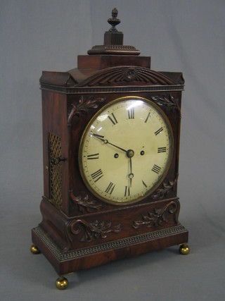 A handsome Georgian 8 day striking fusee bracket clock, the 8 1/2" painted dial with Roman numerals, contained in a carved  mahogany arch shaped case supported by a lidded finial and with rectangular pierced grilled panels to the sides, raised on 4 brass caddy feet (1 missing), having a 5" plain arch shaped back plate and a 4 1/2" circular plain pendulum bob