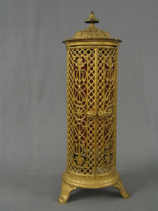 A 19th Century gold painted pierced cast iron Cathedral heater case, enclosed by panelled doors and raised on bracket feet 33"