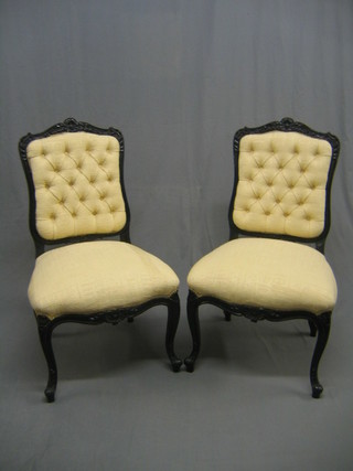A pair of Victorian ebonised salon chairs upholstered in yellow material, raised on French cabriole supports (back legs loose)