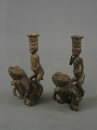 A pair  of Eastern bronze? candlesticks in the form of figures sat upon toads 6"