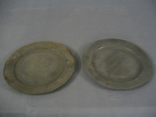 A pair of circular antique pewter plates engraved standing figures within engraved borders 12", the reverse quite plain and unmarked 