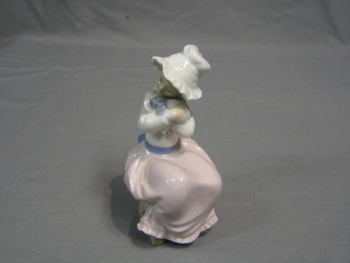 A Nao figure of a seated lady cradling a puppy 7" (head f and r)