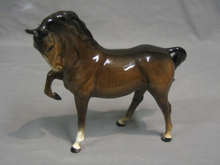 A Beswick figure of a standing bay horse, head tucked, left leg lifted, model no. 1549 (first version brown), 7"