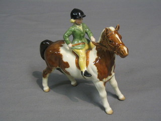 A Beswick figure of a girl riding a skewbald pony, model no. 1499 6"