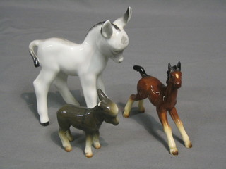A Kelsboie figure of a donkey 3" (ears chipped), a pottery figure of a bay foal 4" and a pottery figure of a white standing foal 5"