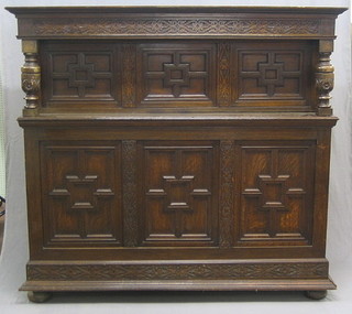A Victorian carved oak court cupboard, the heavily carved apron to the front above 3 panelled doors, the base fitted 3 panelled doors, raised on bun feet 66"