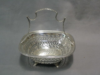 A square pierced silver basket with rope work handle, raised on 4 panel supports, Sheffield 1910, 10 ozs