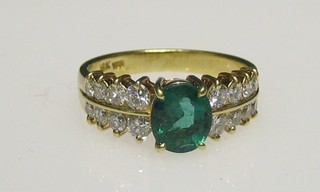 A lady's 18ct gold dress ring set an oval cut emerald surrounded by 16 diamonds
