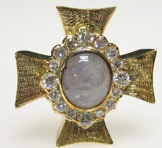 A Greek cross brooch/pendant set a cabouchon cut moonstone surrounded by 16 diamonds