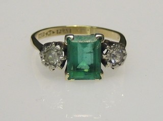 A lady's 9ct gold dress ring set a rectangular cut green stone supported by 2 diamonds
