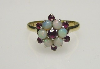 A lady's 18ct gold cluster ring set rubies and opals
