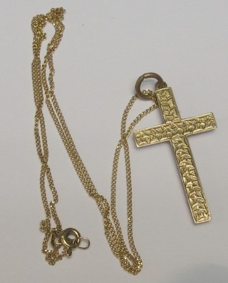 A lady's 9ct gold engraved cross hung on a fine gold chain 