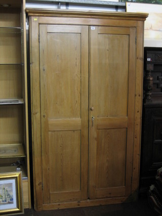 A 19th Century pine cupboard with moulded cornice, the shelved interior enclosed by panelled doors 44"
