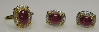 An 18ct gold dress ring set a cabouchon cut red stone supported by white stones, together with a pair of matching earrings