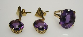 A gold dress ring set an oval cut amethyst together with a pair of matching drop earrings