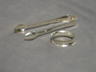 A pair of Georgian silver sugar tongs and a silver napkin ring