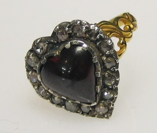 A lady's 18ct gold dress ring set a heart shaped garnet surrounded by 15 diamonds