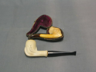 A Meerschaum pipe, the bowl in the form of a claw, together with a cheroot holder in the form of a ladies head, cased
