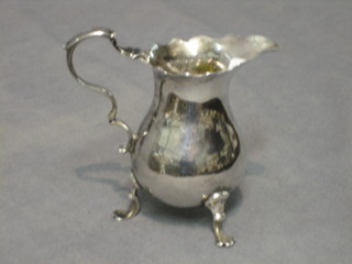 A Georgian plain silver cream jug with wavy border, raised on 3 platform feet 2 ozs