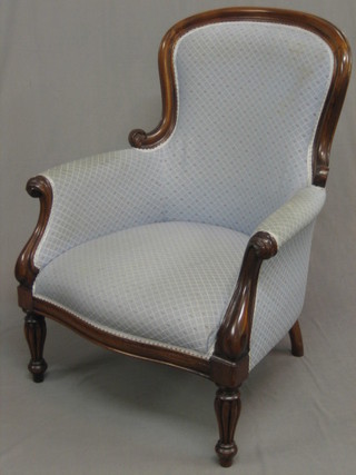 A William IV style mahogany show frame armchair upholstered in green material, raised on turned and reeded supports