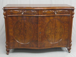 A French mahogany sideboard of serpentine outline, fitted 2 drawers above a double cupboard enclosed by oval panelled doors, raised on cabriole supports 54"
