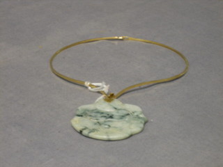 An Eastern engraved jade coloured pendant in the form of a seated Buddha, hung on an 18ct gold necklet
