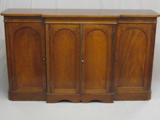 A Victorian mahogany break front triple sideboard, the centre section fitted a cupboard with adjustable shelves enclosed by arched panelled doors flanked by a pair of cupboards 62"