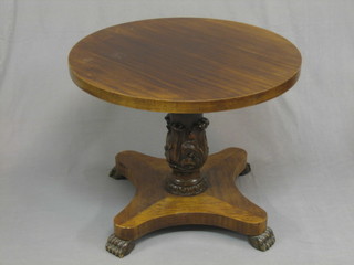 A Victorian style circular mahogany occasional table raised on a carved and fluted column with triform base ending in paw feet 29"