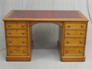 A Victorian honey oak kneehole pedestal desk with inset tooled leather writing surface, above 8 long drawers 54"