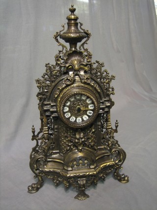 A reproduction French style battery operated mantel clock contained in a pierced metal case
