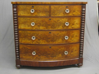A Victorian figured mahogany bow front chest of 2 short and 3 long drawers with glass handles, flanked by bobbin turned columns, raised on bun feet 49"
