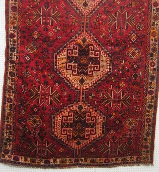 A contemporary Bakhtiari red ground rug with 3 octagons to the centre 96" x 61"