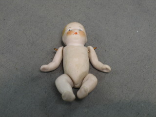 A biscuit porcelain figure of a baby with articulated limbs 3"