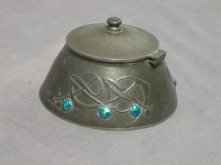 An Art Nouveau circular pewter inkwell with hinged lid and green enamelled decoration, the base marked Tudric 06530 4"