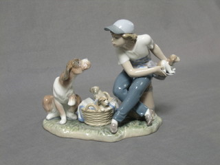 A Lladro figure group of a seated boy with dog and basket of puppies, the base impressed 5376 C14N 7"