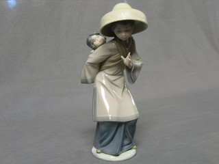 A Lladro figure of a Geisha girl carrying a child, base impressed GE21M 10"