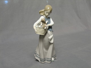 A Lladro figure of a standing girl with basket of puppies, base impressed F19, 10"