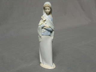 A Lladro figure of  a standing lady with lilies, base marked 5, 9"