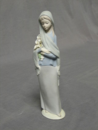 A Lladro biscuit porcelain Lladro figure of a standing girl with lilies, base marked 5, 9"