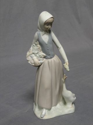 A Nao biscuit porcelain figure of a standing lady with goose 10 1/2"