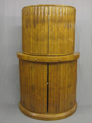 An Art Deco D shaped walnut cocktail cabinet, the upper section enclosed by panelled doors fitted 2 brushing slides to the base above double cupboards 43"
