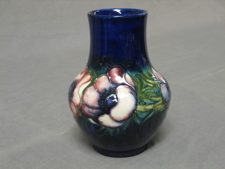 A Moorcroft blue ground club shaped vase decorated Anemone, the base impressed Made in England and with signature mark and paper label, 7"